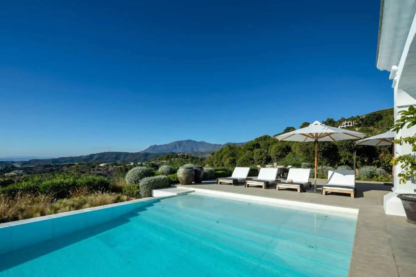 Luxury mansion with infinity pool overlooking Marbella and surrounding mountains.