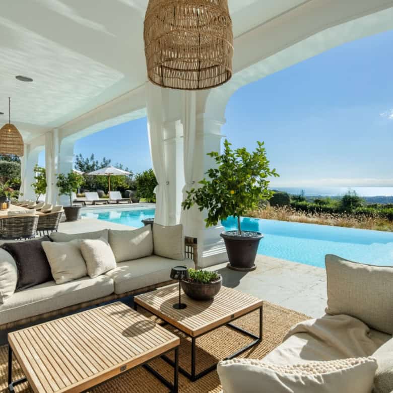 Elegant outdoor lounge with pool and panoramic landscape views in Marbella. Perfect for relaxing and.
