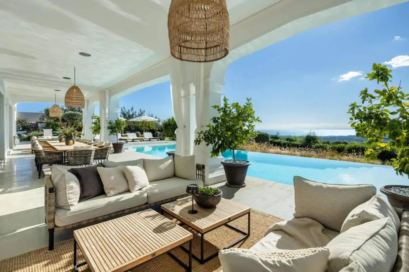 Elegant outdoor lounge with pool and panoramic landscape views in Marbella. Perfect for relaxing and.