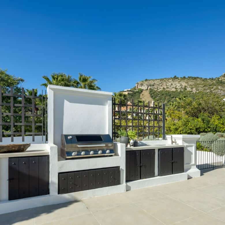 Outdoor kitchen with built-in grill in Marbella mansion.