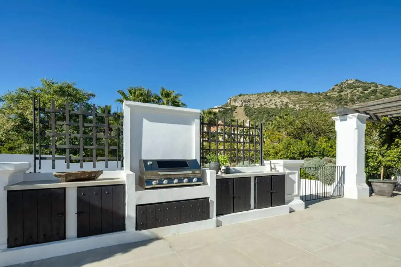 Outdoor kitchen with built-in grill in Marbella mansion.