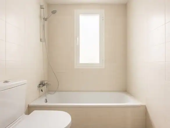 Bathroom with bathtub and shower in Puerto Banus townhouse, featuring neutral tiles and a frosted wi.