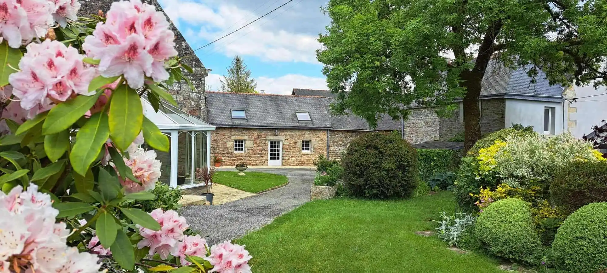 Elegant 12-bedroom estate for sale in Scaer, Brittany, featuring beautiful gardens and historic arch.