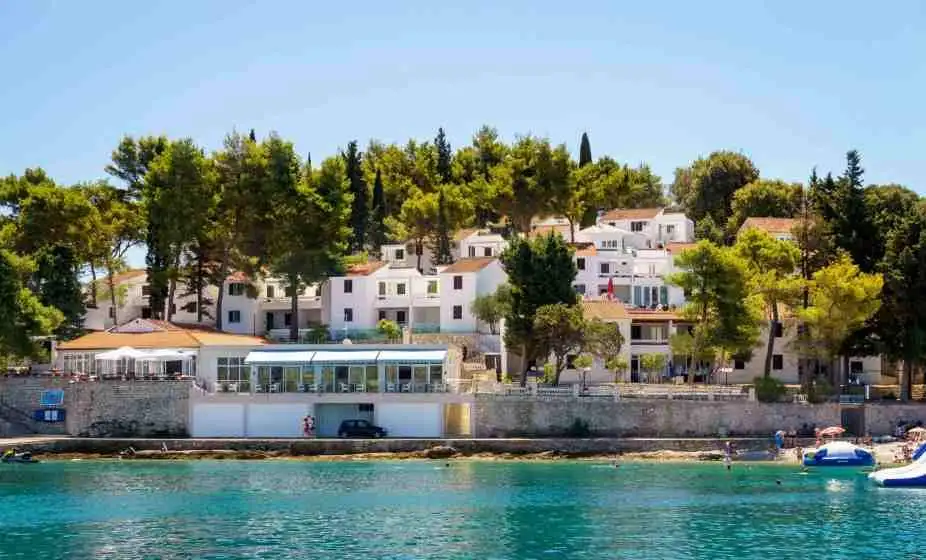 Beautiful seaside view of Lumbarda resort with white villas and lush greenery in Korčula, Croatia.