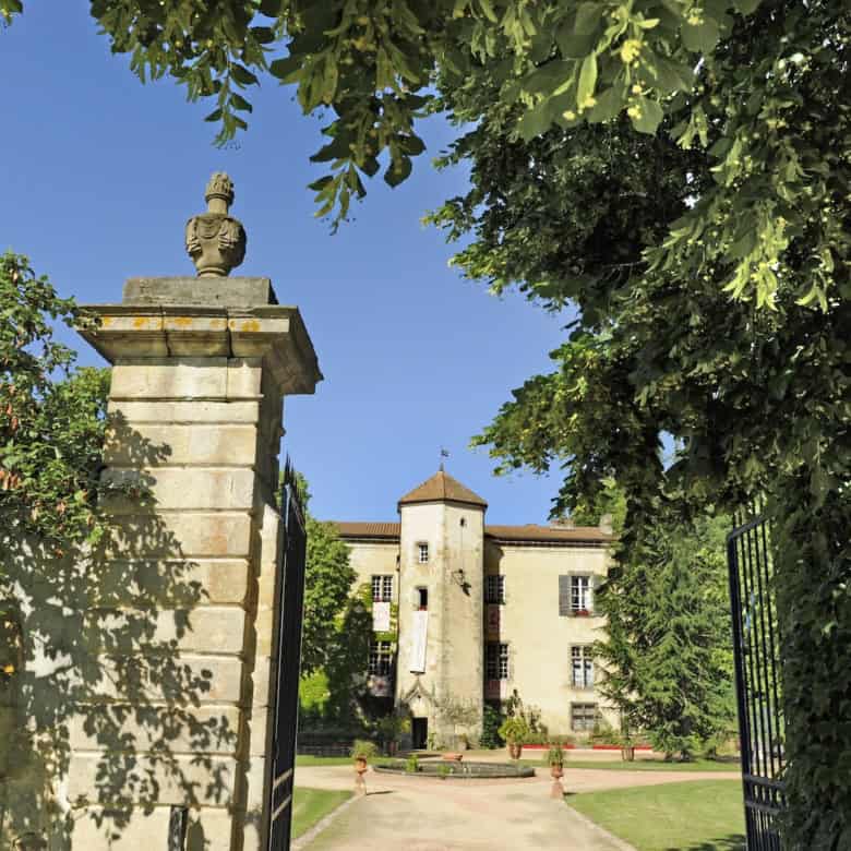 Château de la Chassaigne with lush gardens and historic architecture in Thiers, France.