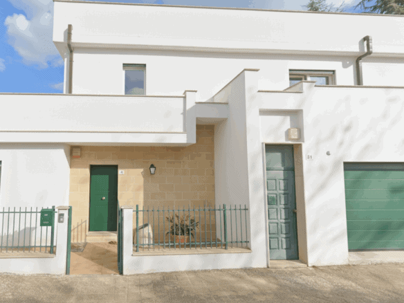 Contemporary white townhouse with green accents in Bernalda Italy.