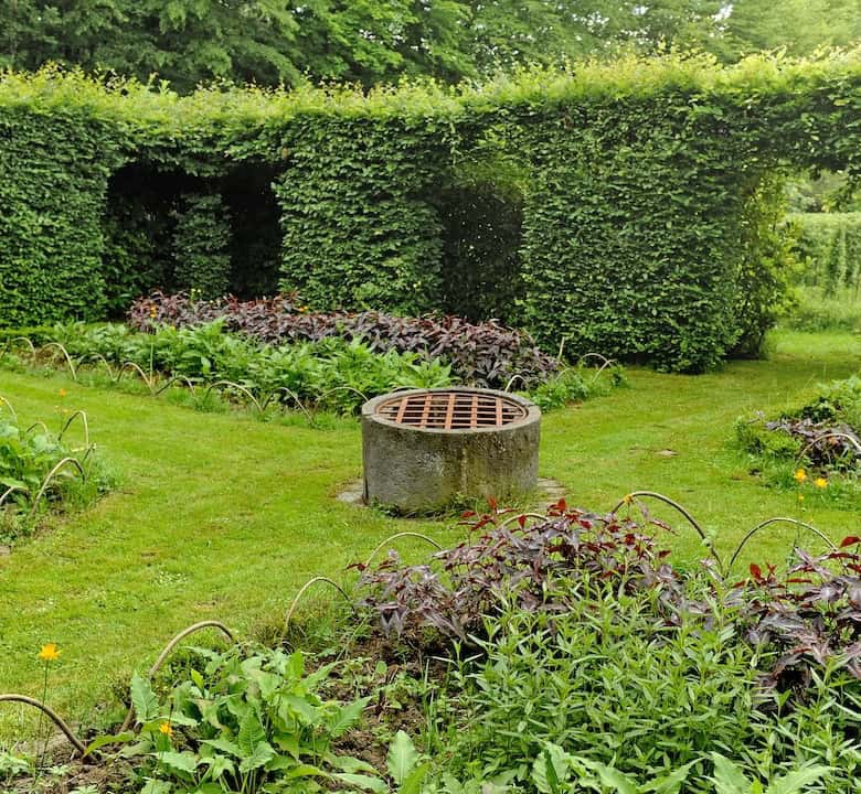 Château de la Chassaigne garden with lush greenery and manicured hedges in Thiers, France.