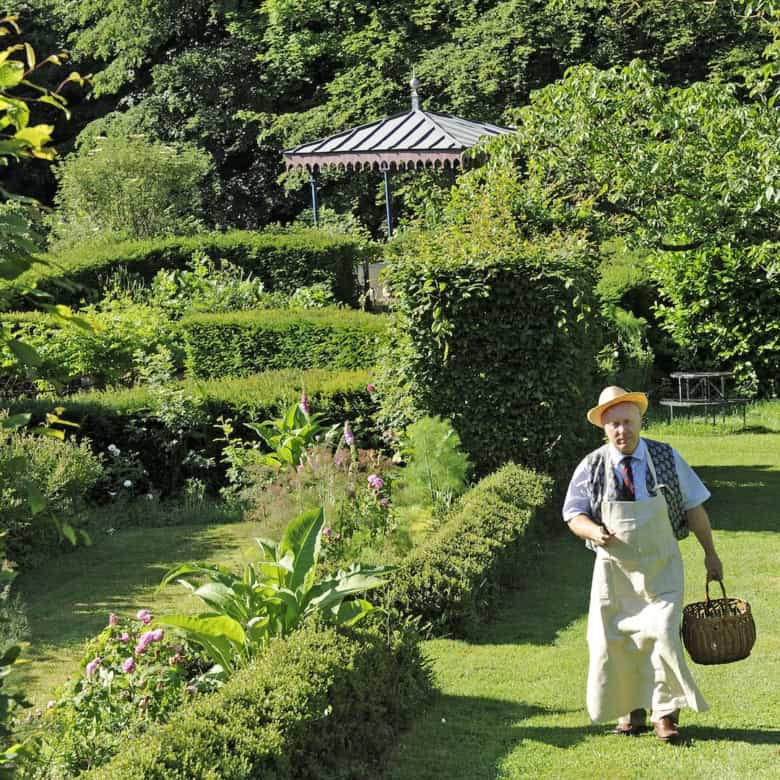 Château de la Chassaigne garden with lush greenery and a person enjoying the serene landscape in Thi.