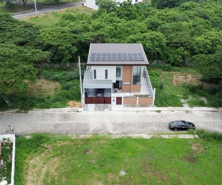 Contemporary villa with solar panels located in a lush green area in Dasmarinas, Philippines.