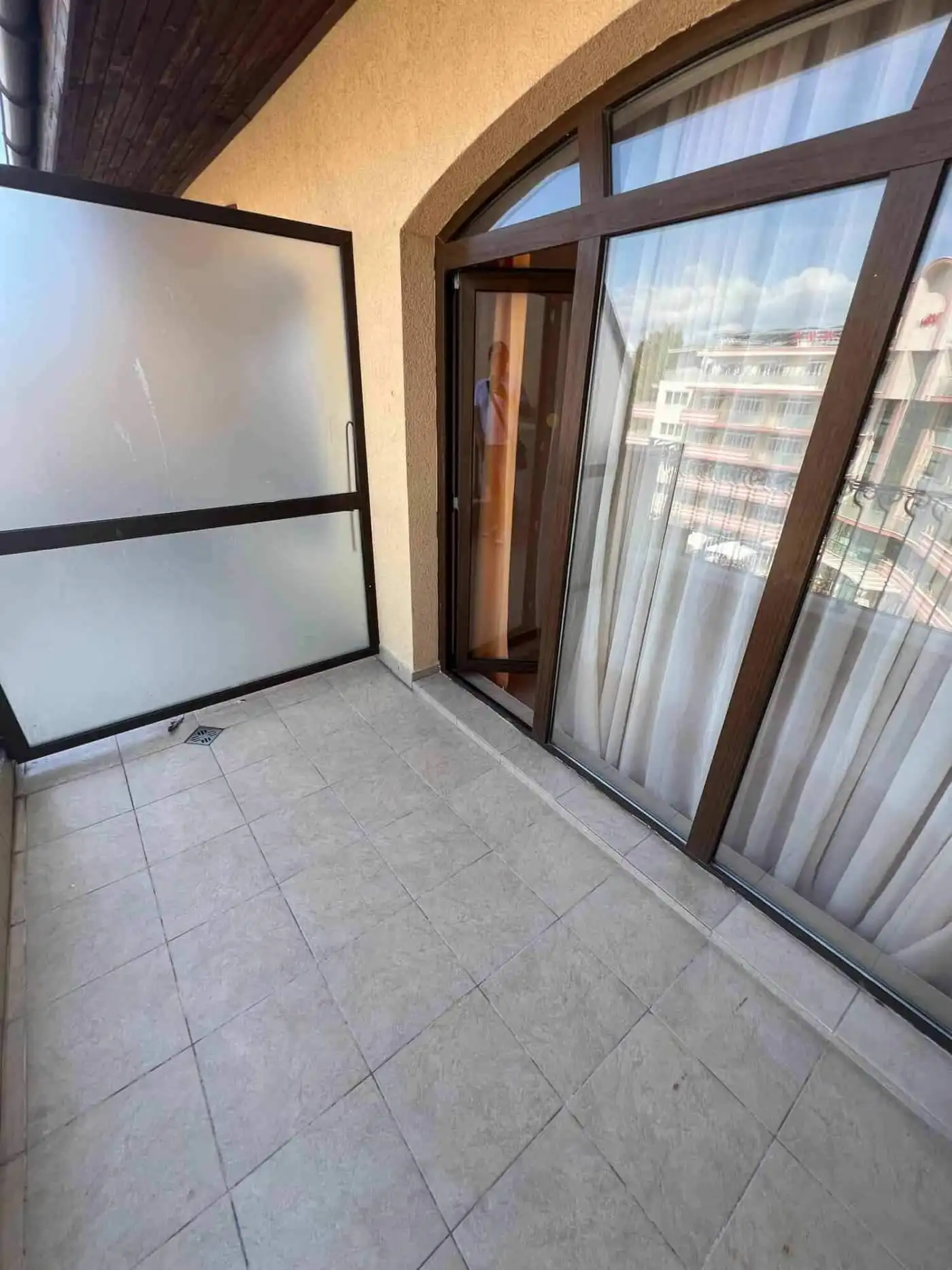 Balcony overlooking pool with glass doors in Sunny Beach apartment.