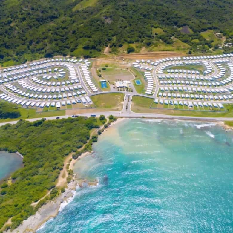 Aerial view of Ocean Pointe resort with luxury homes and lush greenery near the Caribbean coast.