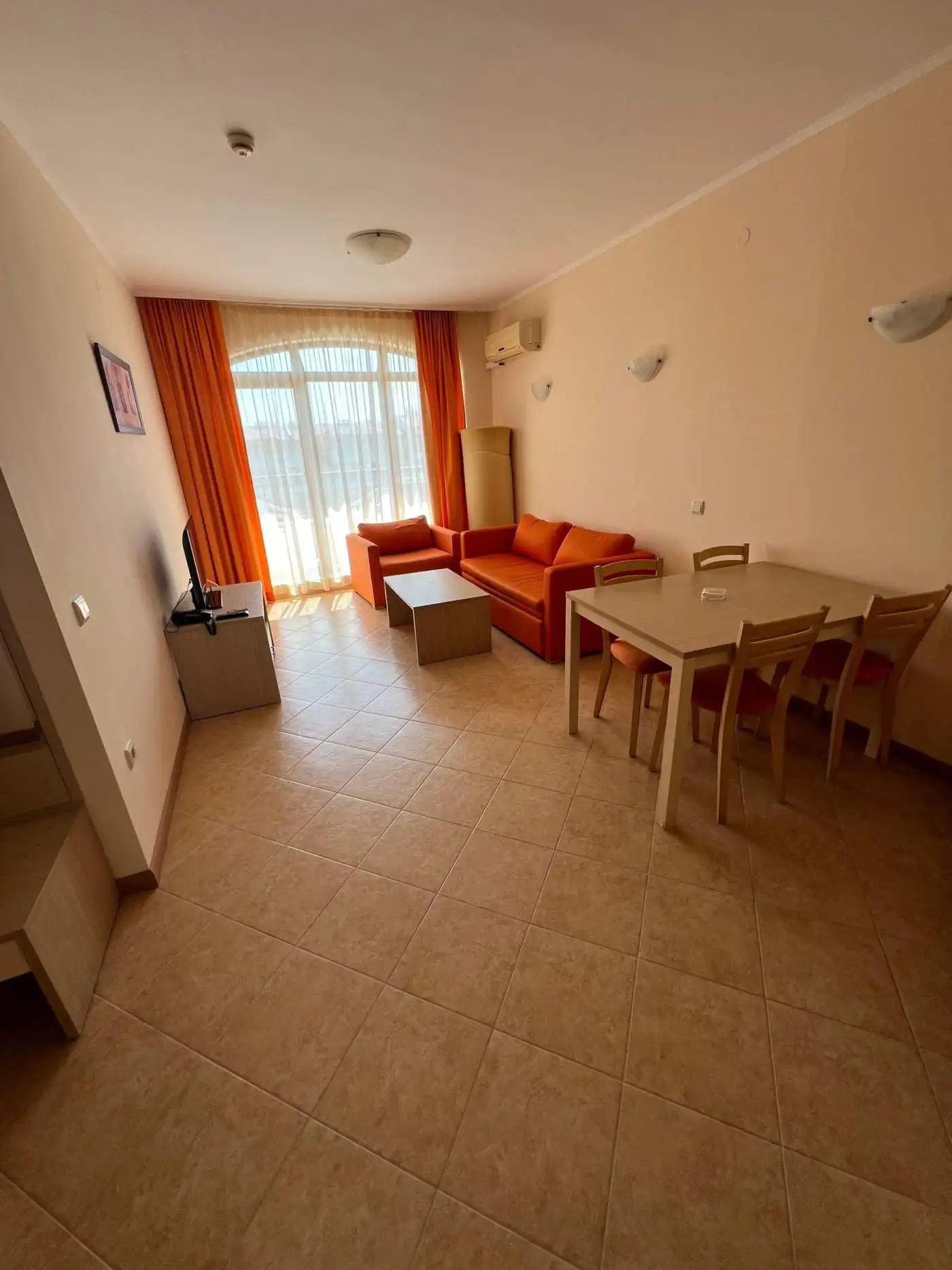 Interior of a 1-bedroom apartment with pool view, sunny beach, and modern furnishings.