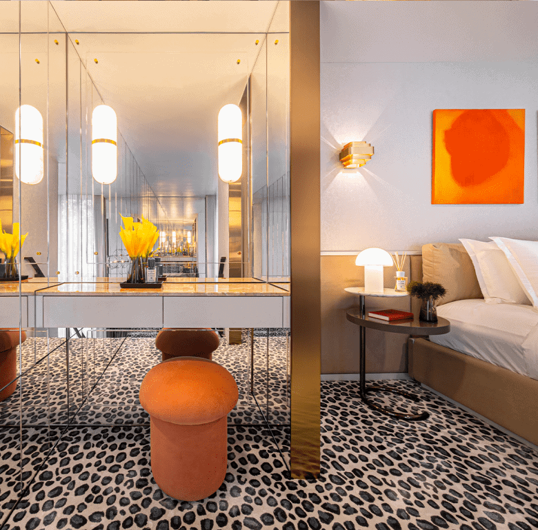 Contemporary hotel room in Bangkok with vibrant artwork and cozy seating area.