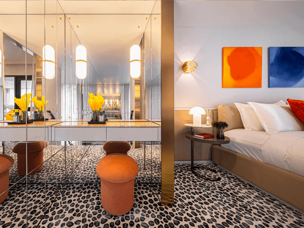 Contemporary hotel room in Bangkok with vibrant artwork and cozy seating area.