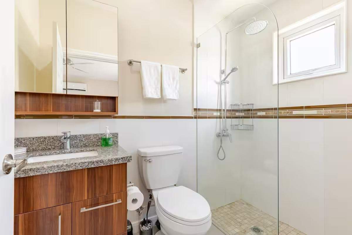 Modern bathroom with shower and vanity in a luxury Jamaican home Luxury bathroom with walk-in shower and contemporary fixtures in a Jamaican seaside property.