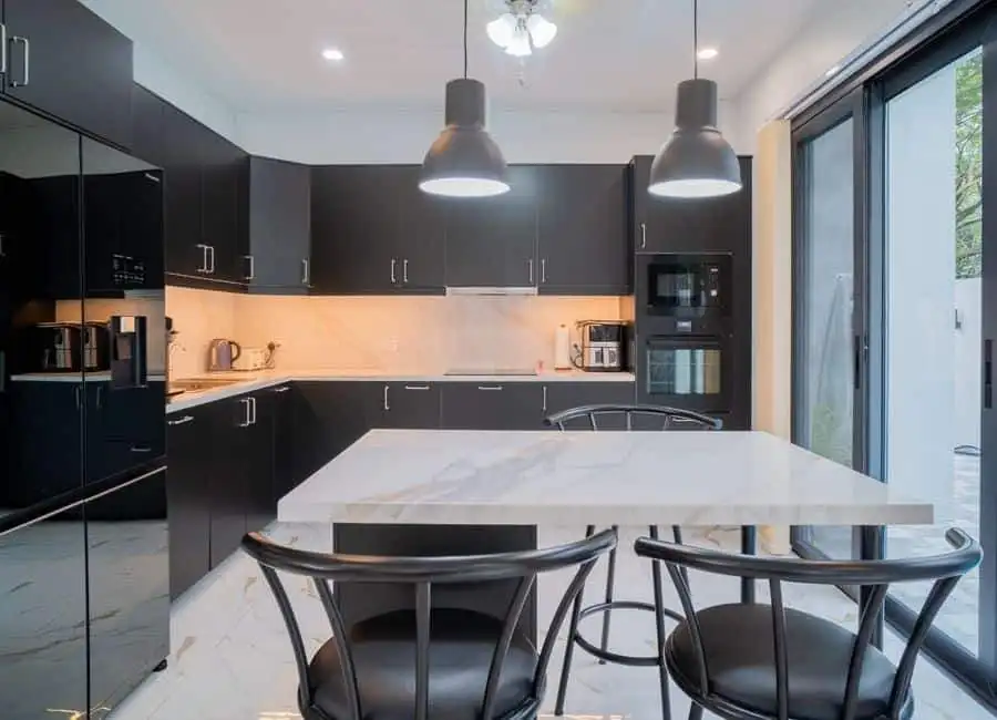 Modern Black Kitchen with Marble Countertop Elegant black kitchen with marble island and modern appliances. Bright, spacious, and perfect for co.