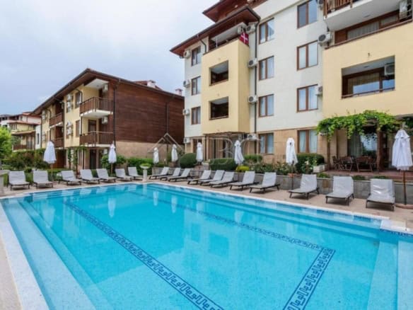 Outdoor swimming pool at a modern apartment complex in Sveti Vlas, Bulgaria, with sun loungers and g.