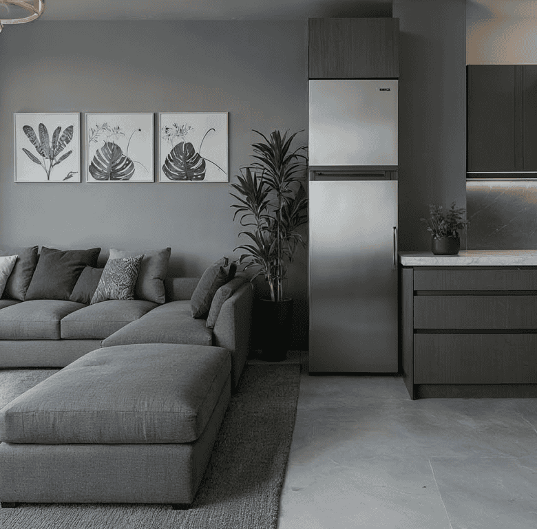 Modern living room with gray sofa and kitchen area in Portside Residences, Athens, Greece.