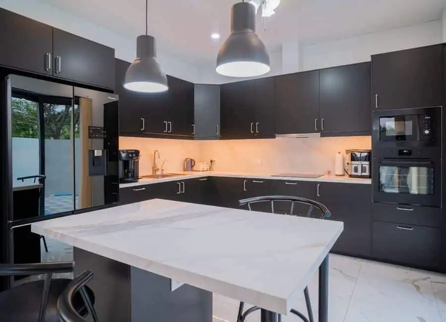 Modern Black Kitchen with Island Modern black kitchen with sleek cabinetry and a central island for cooking and dining. Bright lighti.