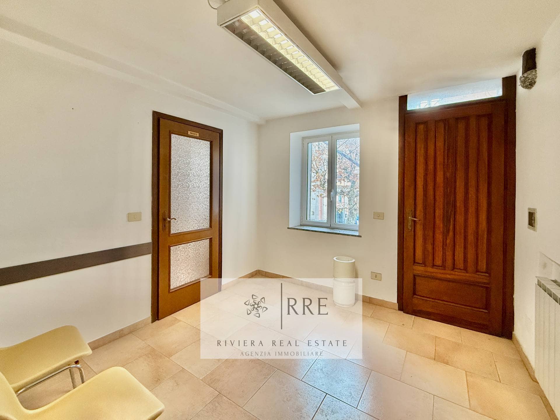 Cozy room featuring wooden doors, a window with natural light, and tiled flooring.