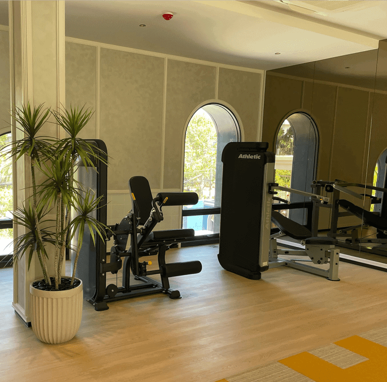 Gym room in Hua Hin cabanas with fitness equipment and natural light.