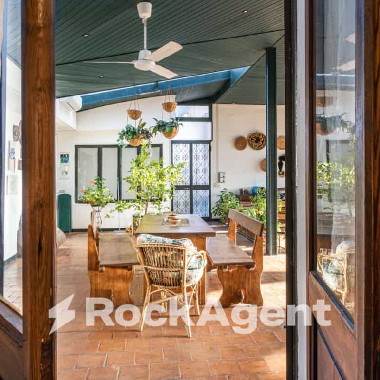 Elegant villa interior with spacious dining area and lush greenery views.