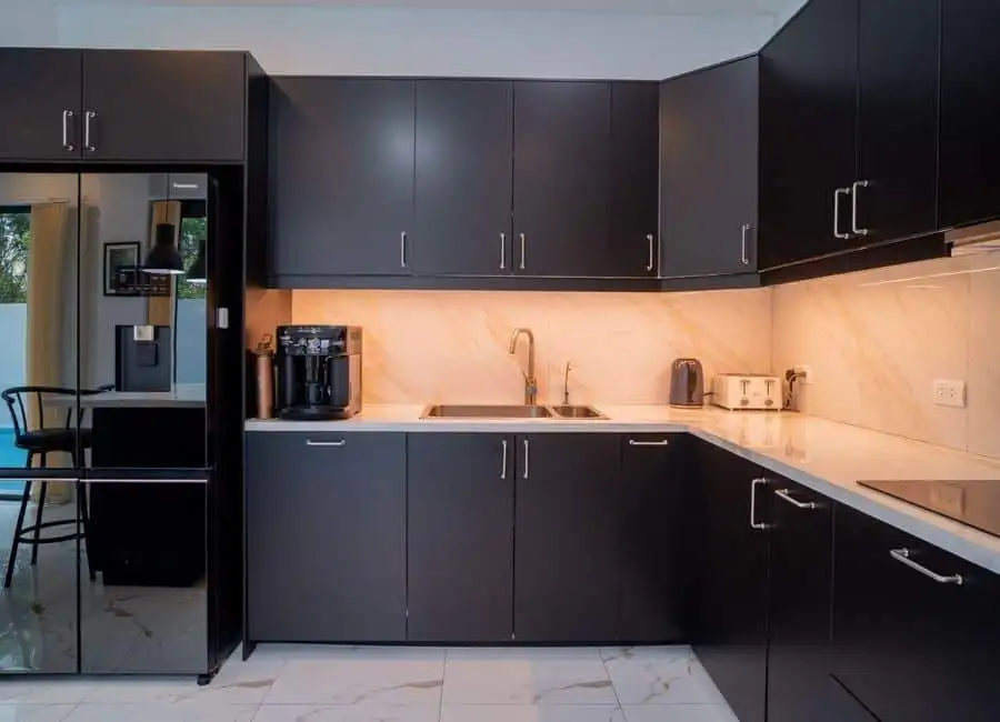 Modern black kitchen with marble countertops and appliances Modern black kitchen with marble countertops, coffee machine, and sleek cabinetry in a luxury villa.