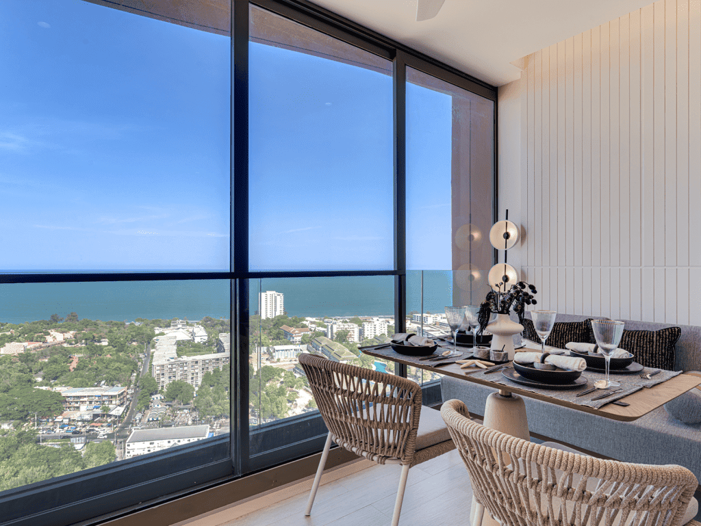Ocean view dining space in Hua Hin, Thailand with stylish furniture and large windows.