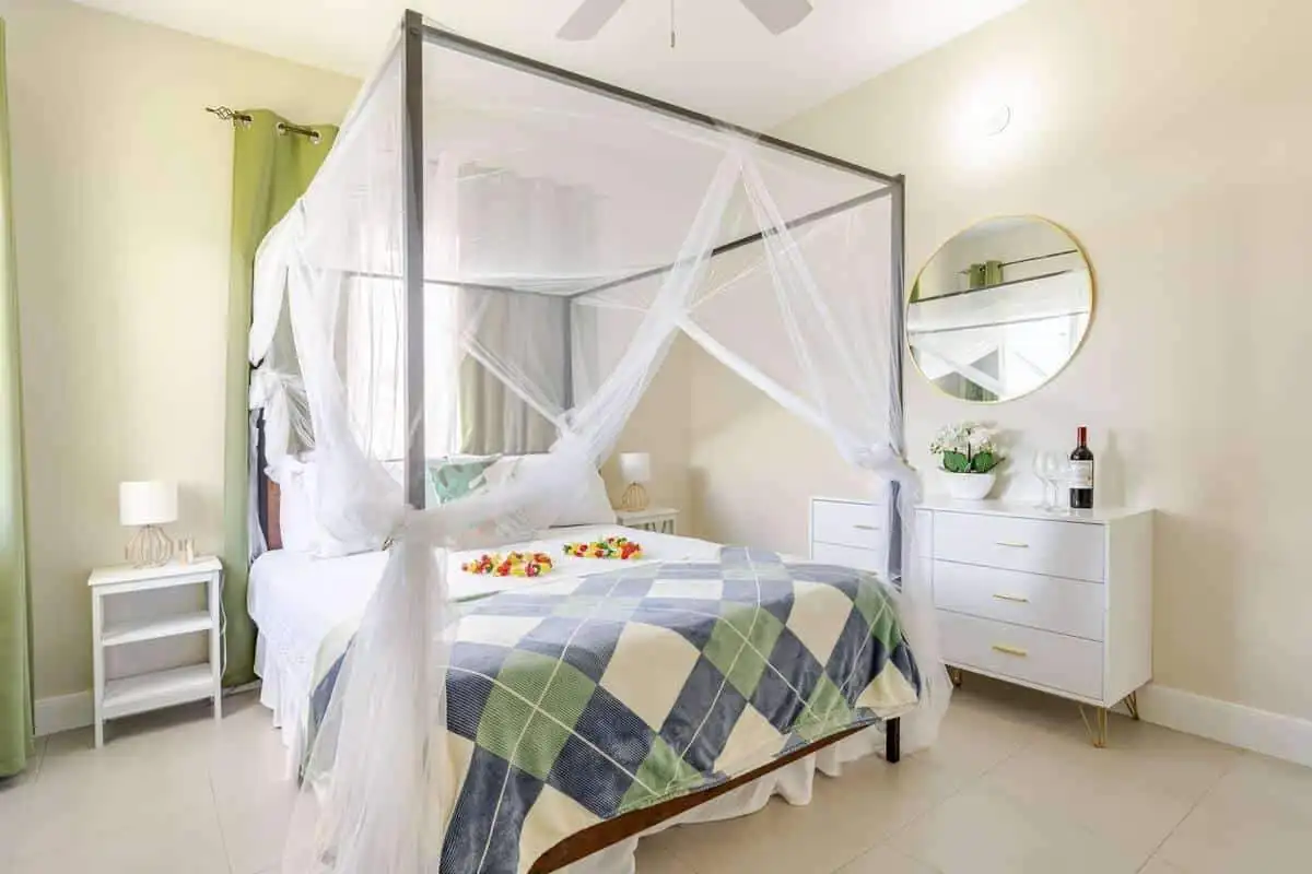 Luxury 3-Bedroom Bedroom in Jamaica Elegant bedroom with a four-poster bed and mosquito net in a tropical home.