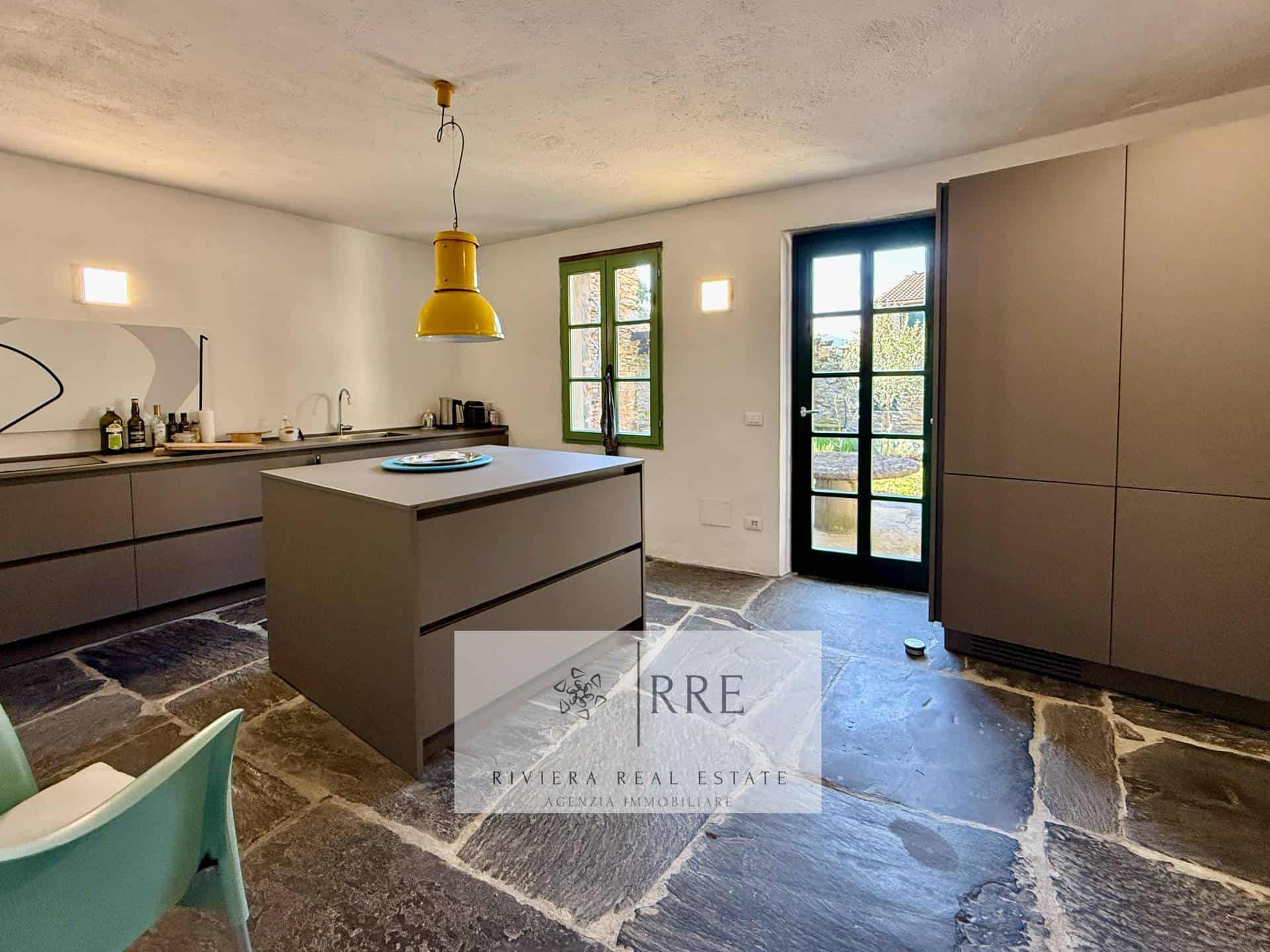 Modern kitchen with minimalist design, large windows, and a central island for cooking and dining.