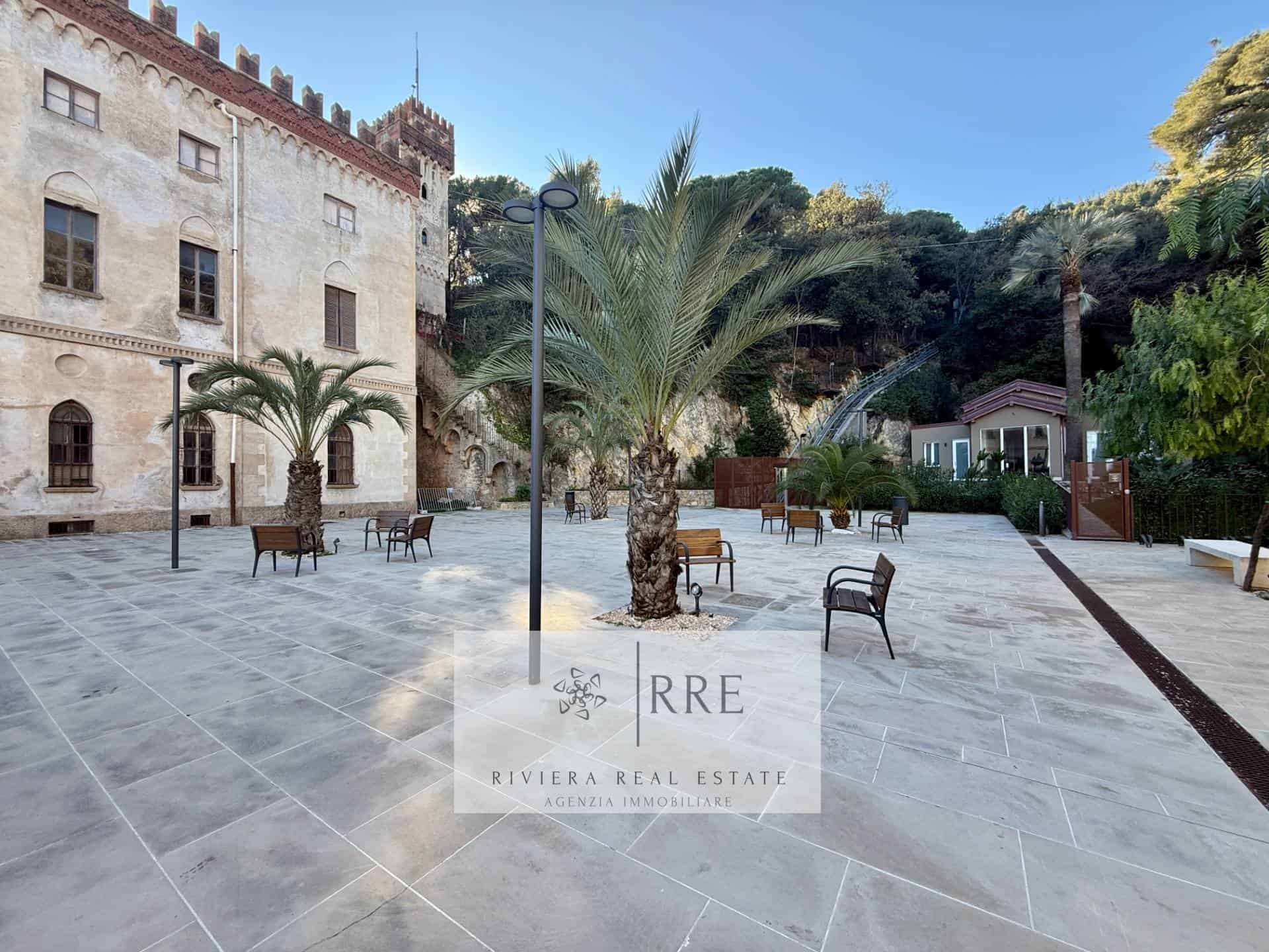 Beautiful European castle courtyard with palm trees and benches, perfect for relaxing or sightseeing.