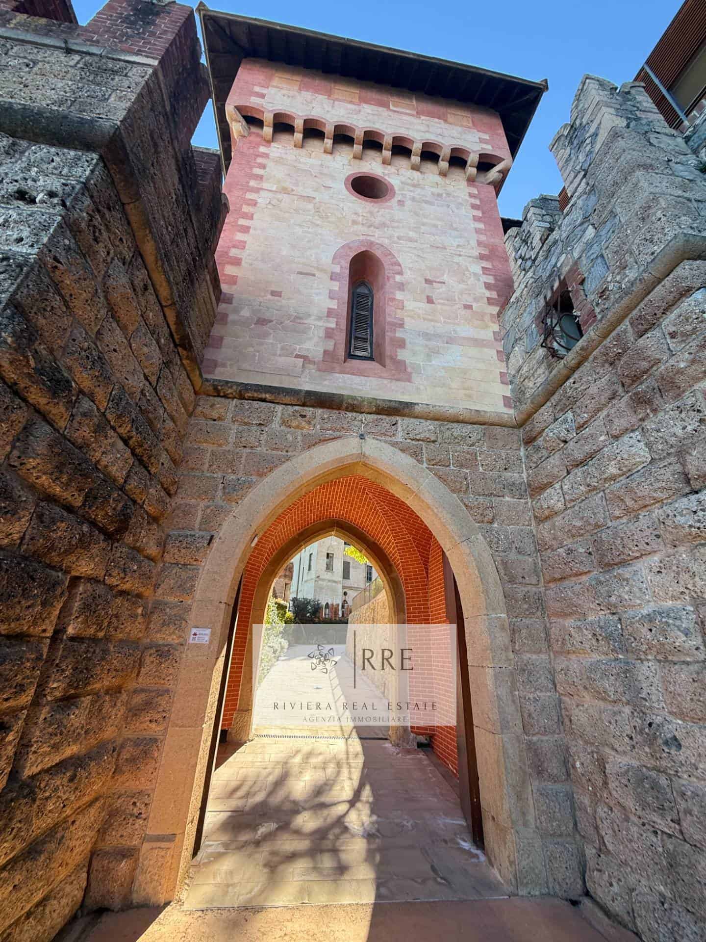 Ancient stone tower with arched entrance and medieval architecture.