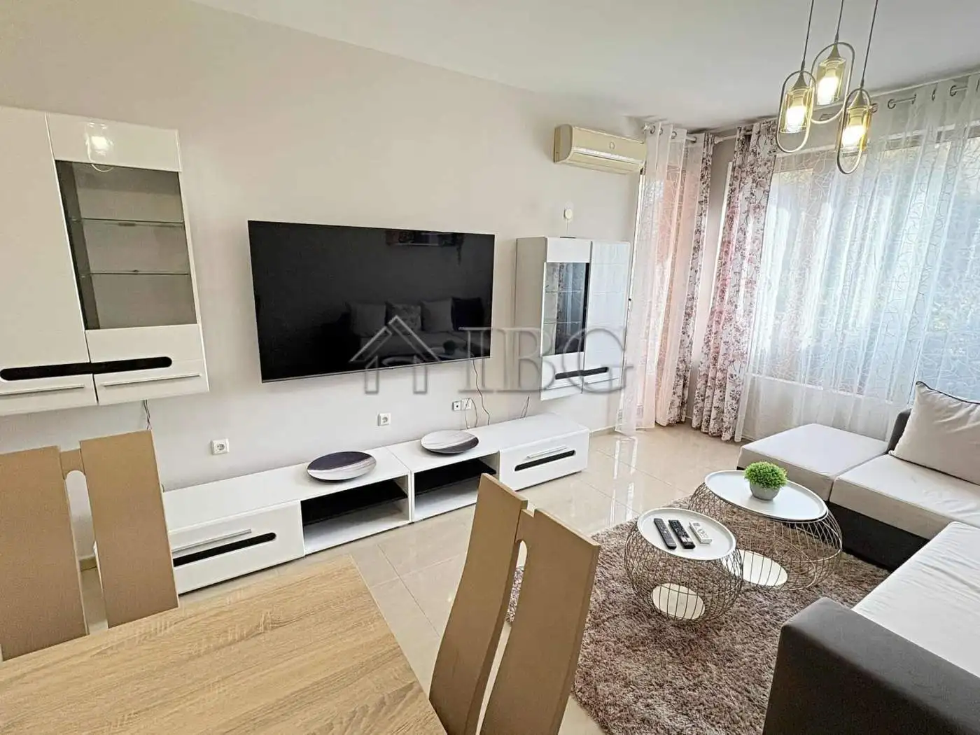 Modern living room with wall-mounted TV and contemporary furniture.