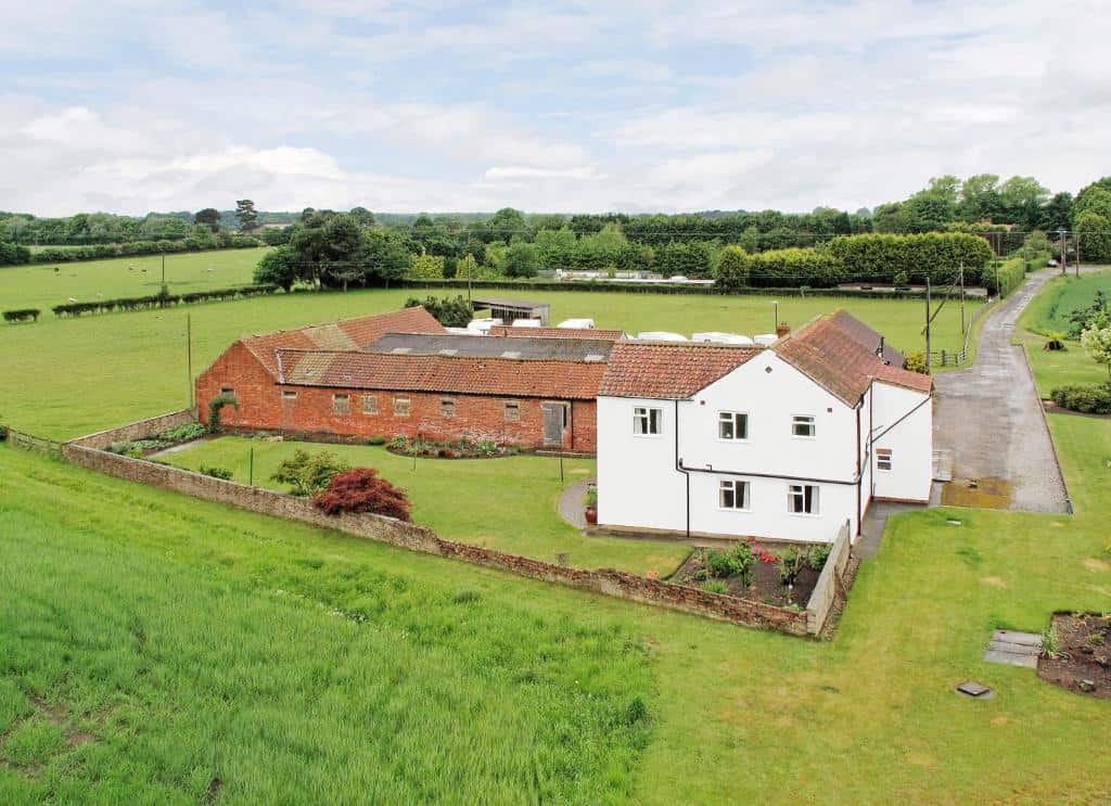 Country House with Garden and Rural Landscape Country house with garden and surrounding green fields in a rural setting.