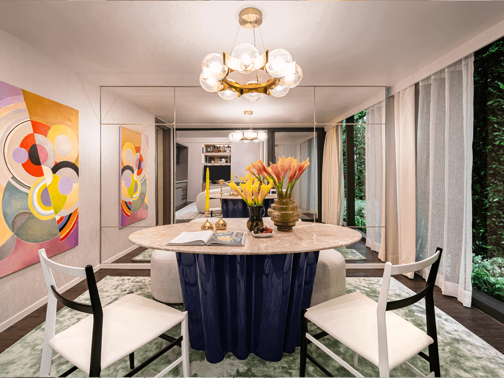 Stylish Bangkok dining room with modern art, chandelier, and lush greenery outside.