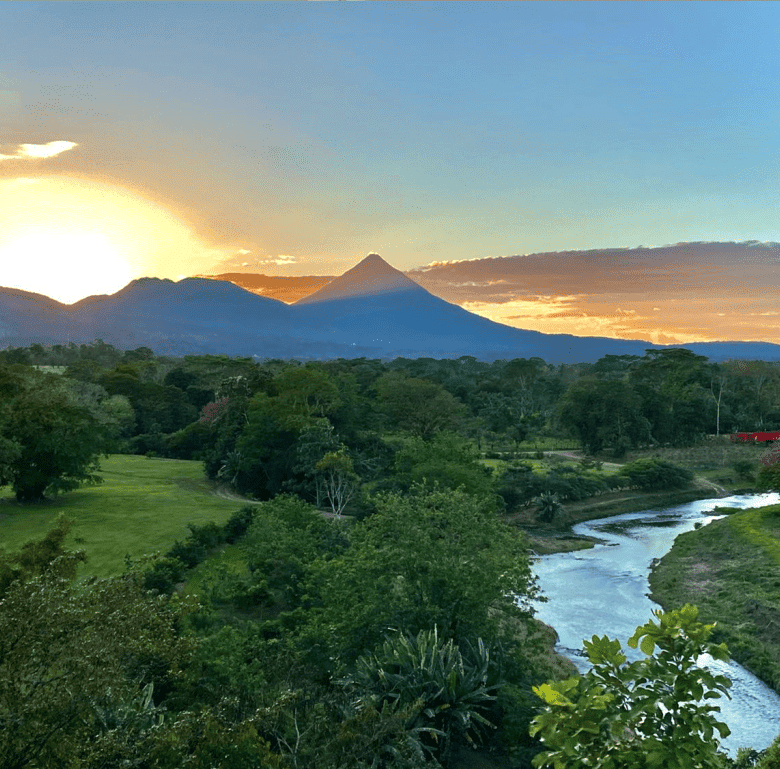 Arenal Hills scenic view with volcano, lush greenery, and river in La Fortuna, Costa Rica.