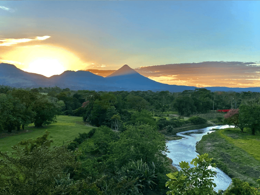 Arenal Hills scenic view with volcano, lush greenery, and river in La Fortuna, Costa Rica.