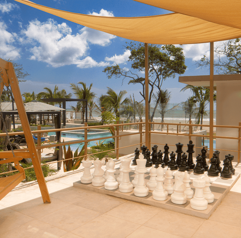 Beachfront terrace with chess and shaded seating area in Surfside, Playa Caracol, Panama.