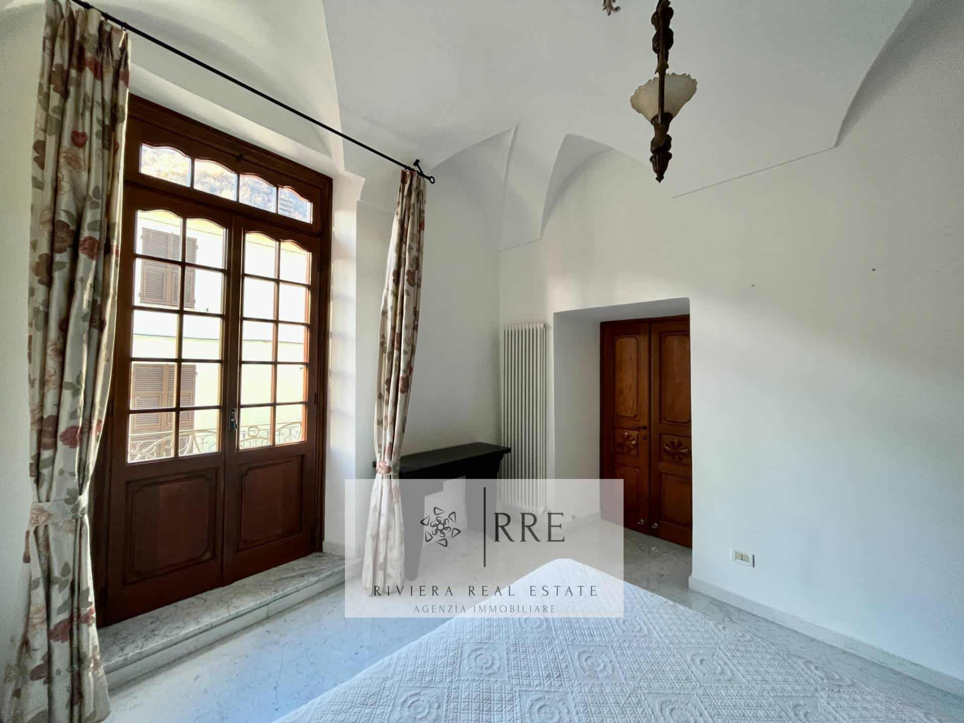 Room with wooden door and large window in a traditional Spanish-style home.