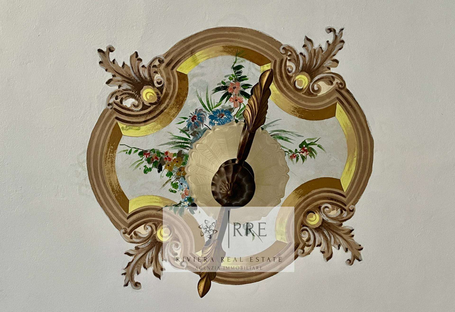 Vintage floral wall clock with ornate frame and decorative details.