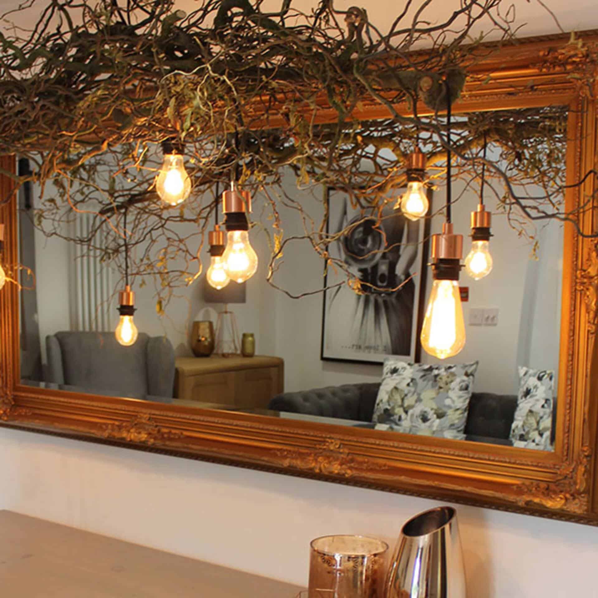Modern interior with hanging light bulbs and decorative mirror Stylish living room with hanging light bulbs and large mirror.
