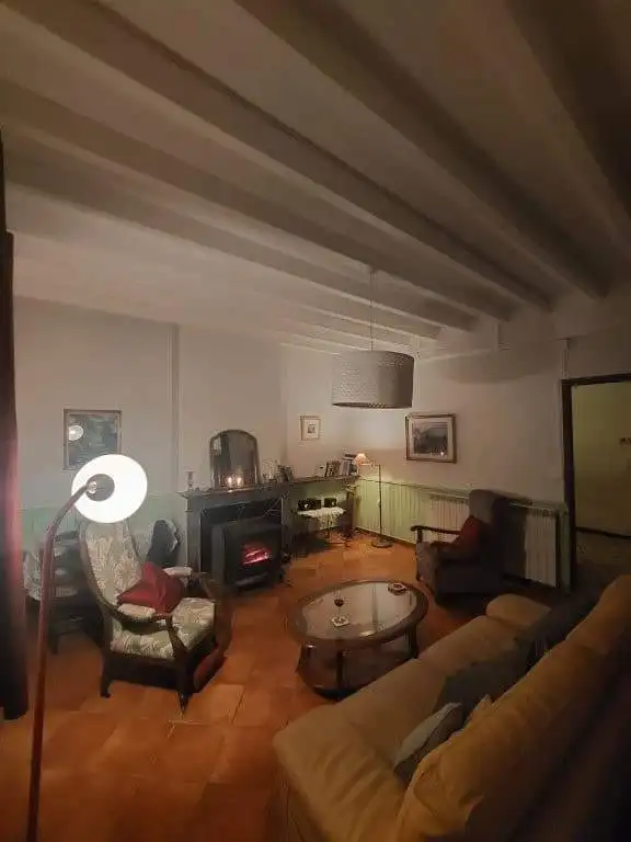 Cozy farmhouse living room with vintage furniture, warm lighting, and rustic decor in Madiran Villag.