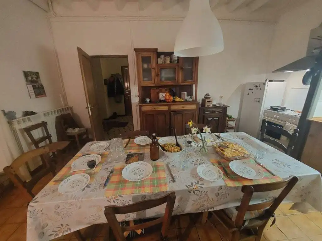 Charming Farmhouse Dining Room in Madiran France Cozy farmhouse dining area with a large table set for a family meal in Madiran Village, France.