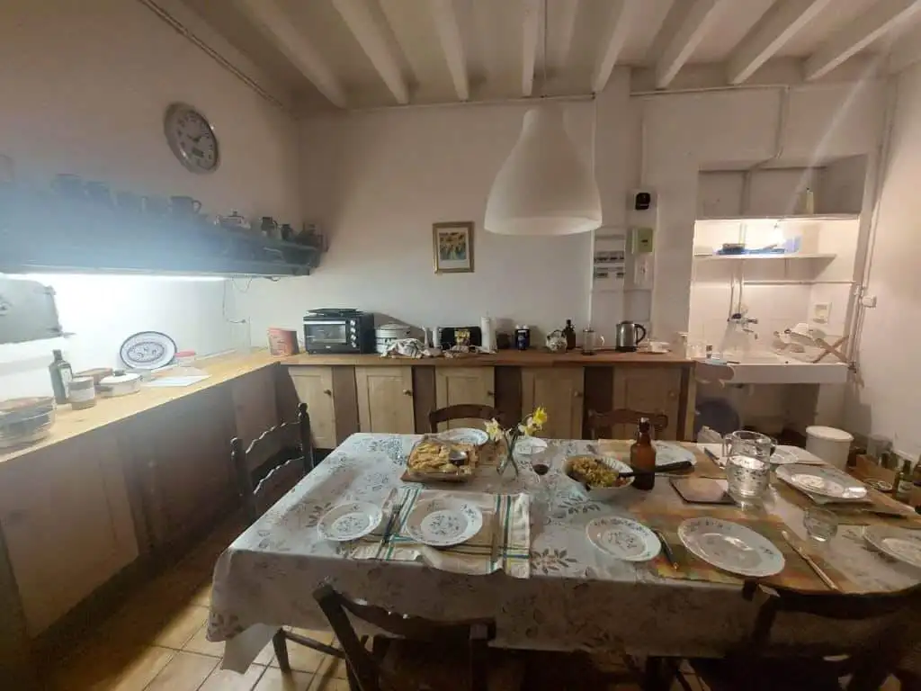 Charming Farmhouse Kitchen in Madiran France Cozy farmhouse kitchen with rustic wooden cabinets and a large dining table set for a family meal.