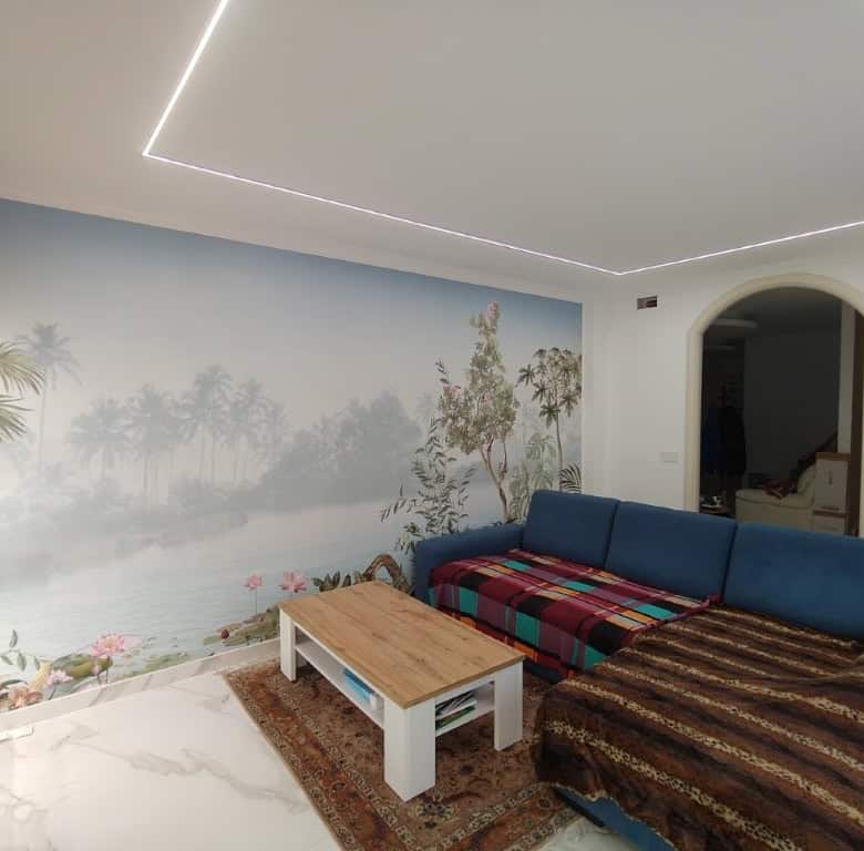 Bright living space with tropical mural and modern lighting in Bernalda Italy.