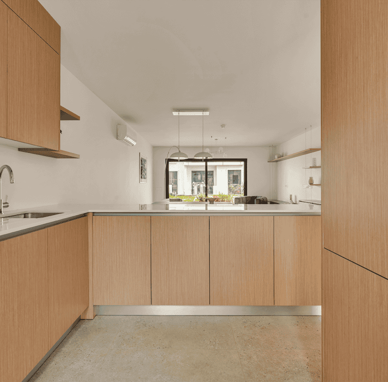 Modern Algarve kitchen with wooden cabinets, bright natural light, and a minimalist design.