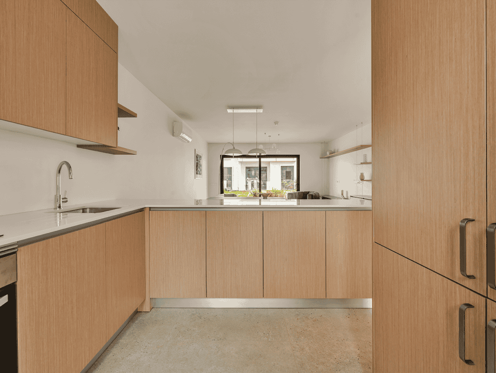 Modern Algarve kitchen with wooden cabinets, bright natural light, and a minimalist design.