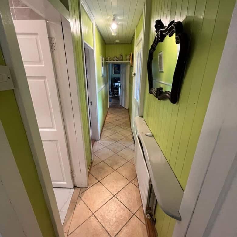 Charming Irish cottage hallway with vibrant green walls and traditional decor.