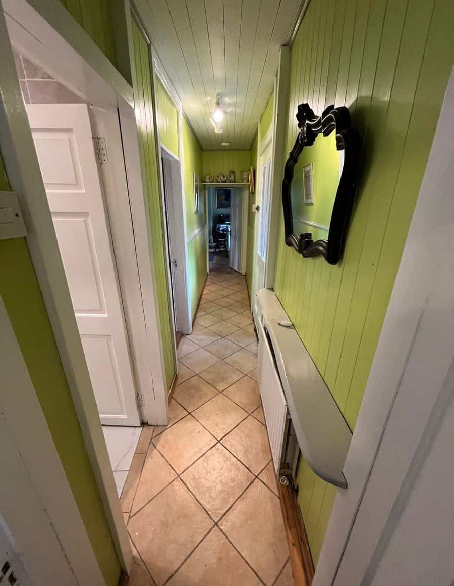 Charming Irish cottage hallway with vibrant green walls and traditional decor.