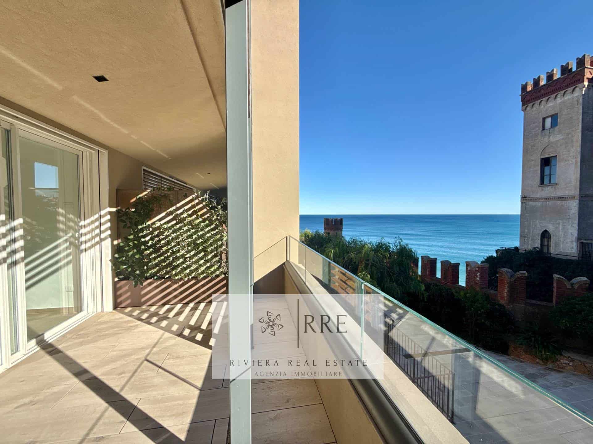 Seaside apartment with balcony overlooking the ocean and historic castle in the background.